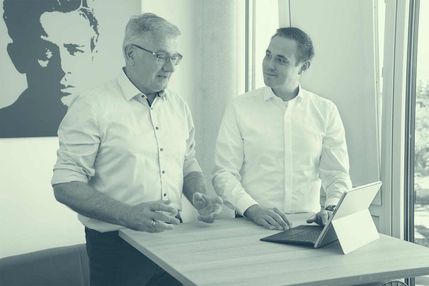 Michael Winter und Marco Sarcoli im Gespräch am Stehtisch mit Tablet